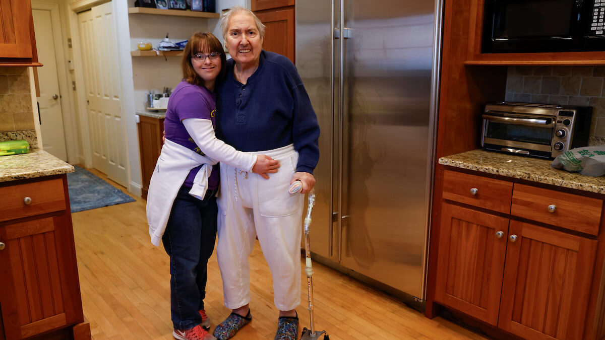 Marquis and Sue pose for a photo together inside of a kitchen.