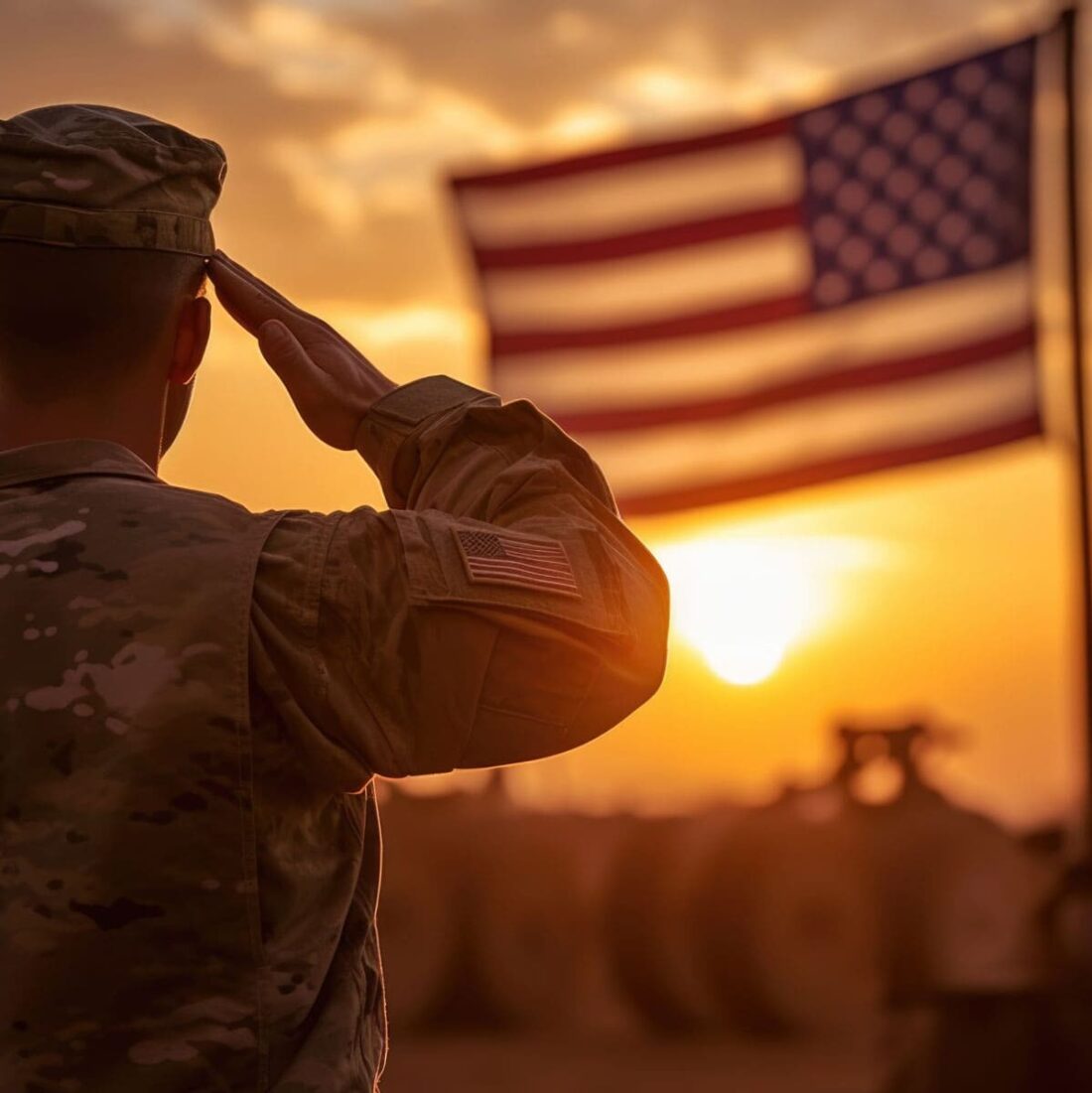 Soldier saluting a flag during while the sun goes down.
