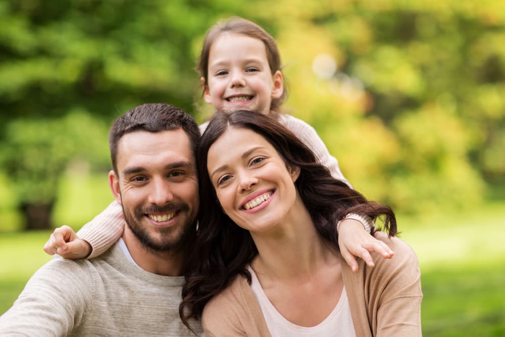 outdoor family portrait with mother, father and daughter