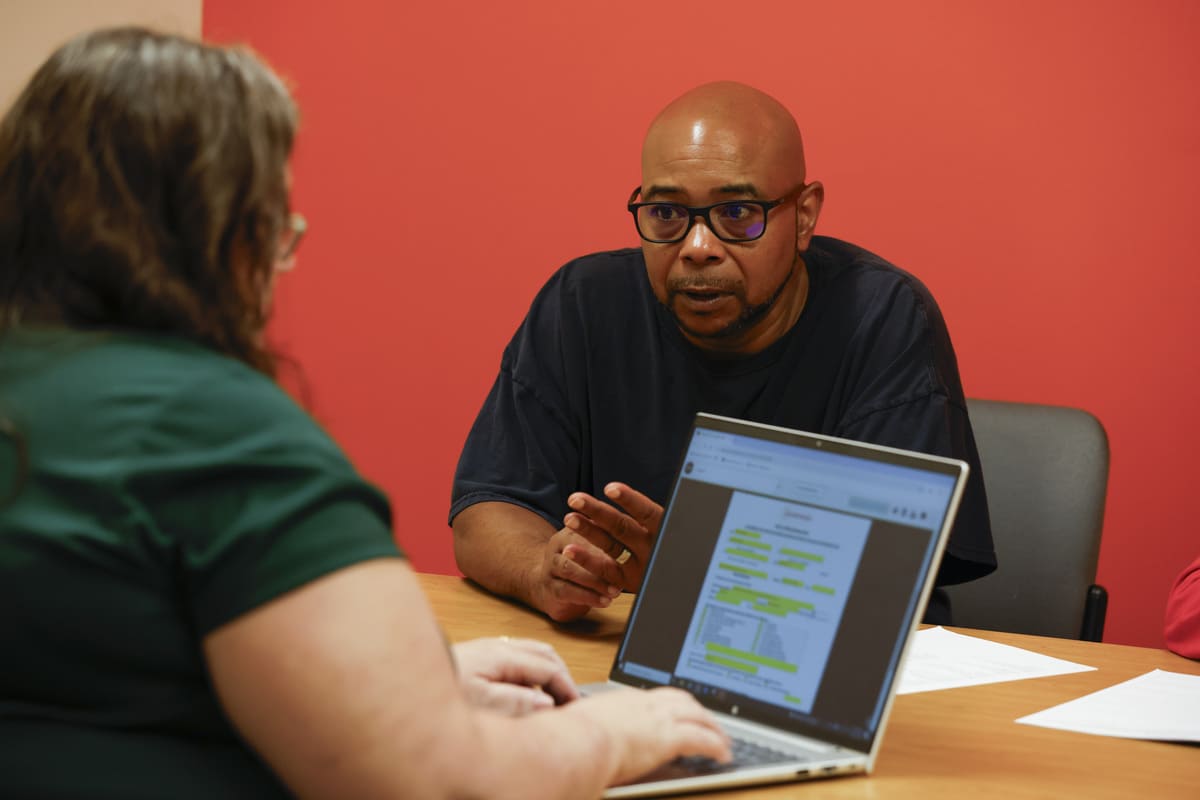Shawn talking with Veterans Count staff member across a table