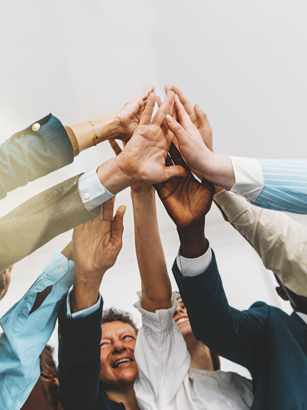 Group of people with hands raised.